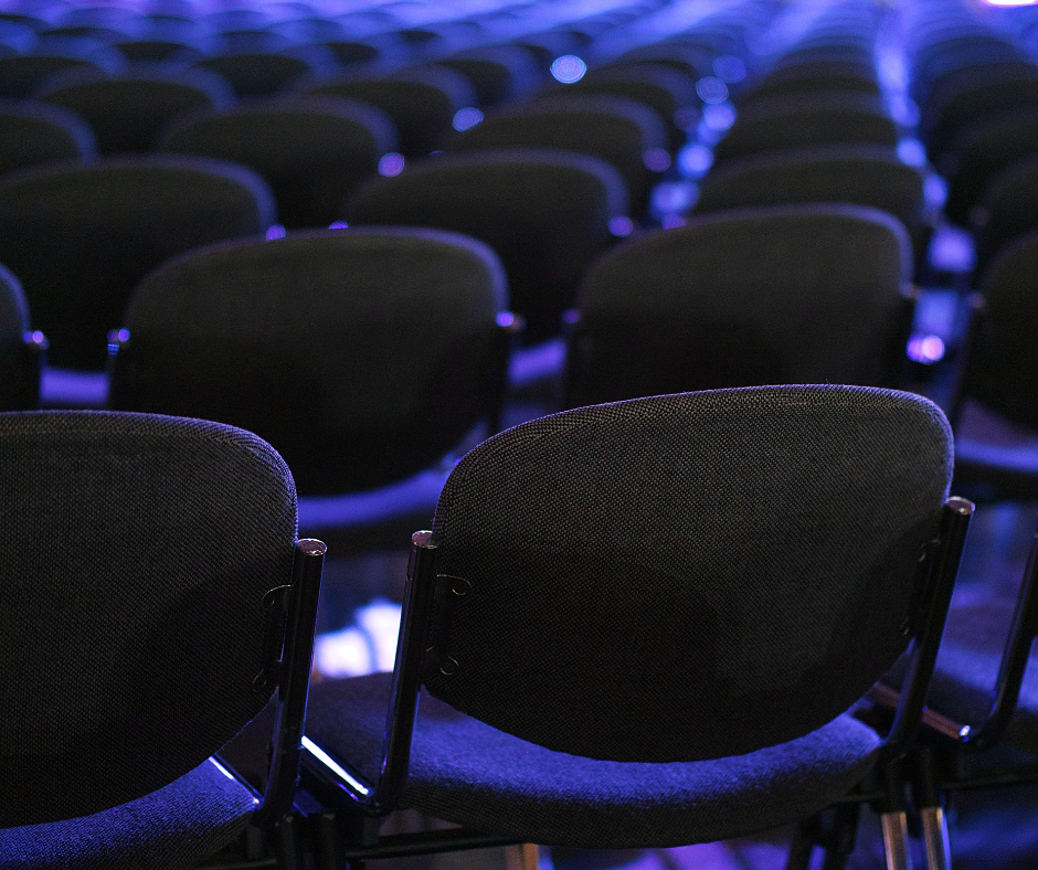 blue chairs in a row that are empty in a room for a breakout session