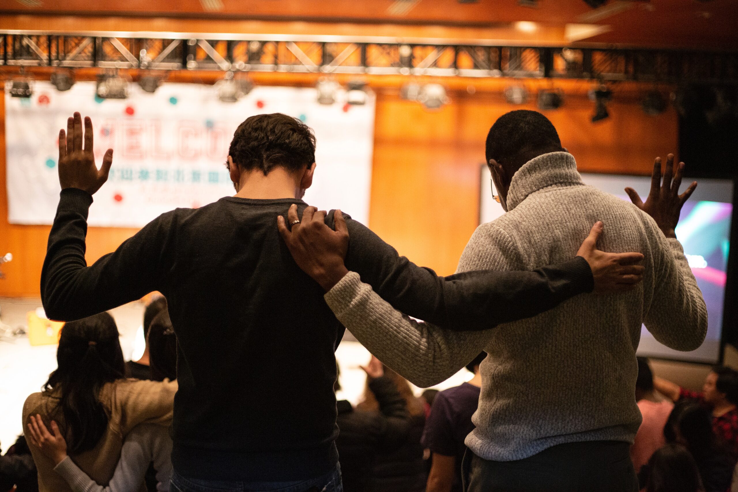 two men praying together at an event