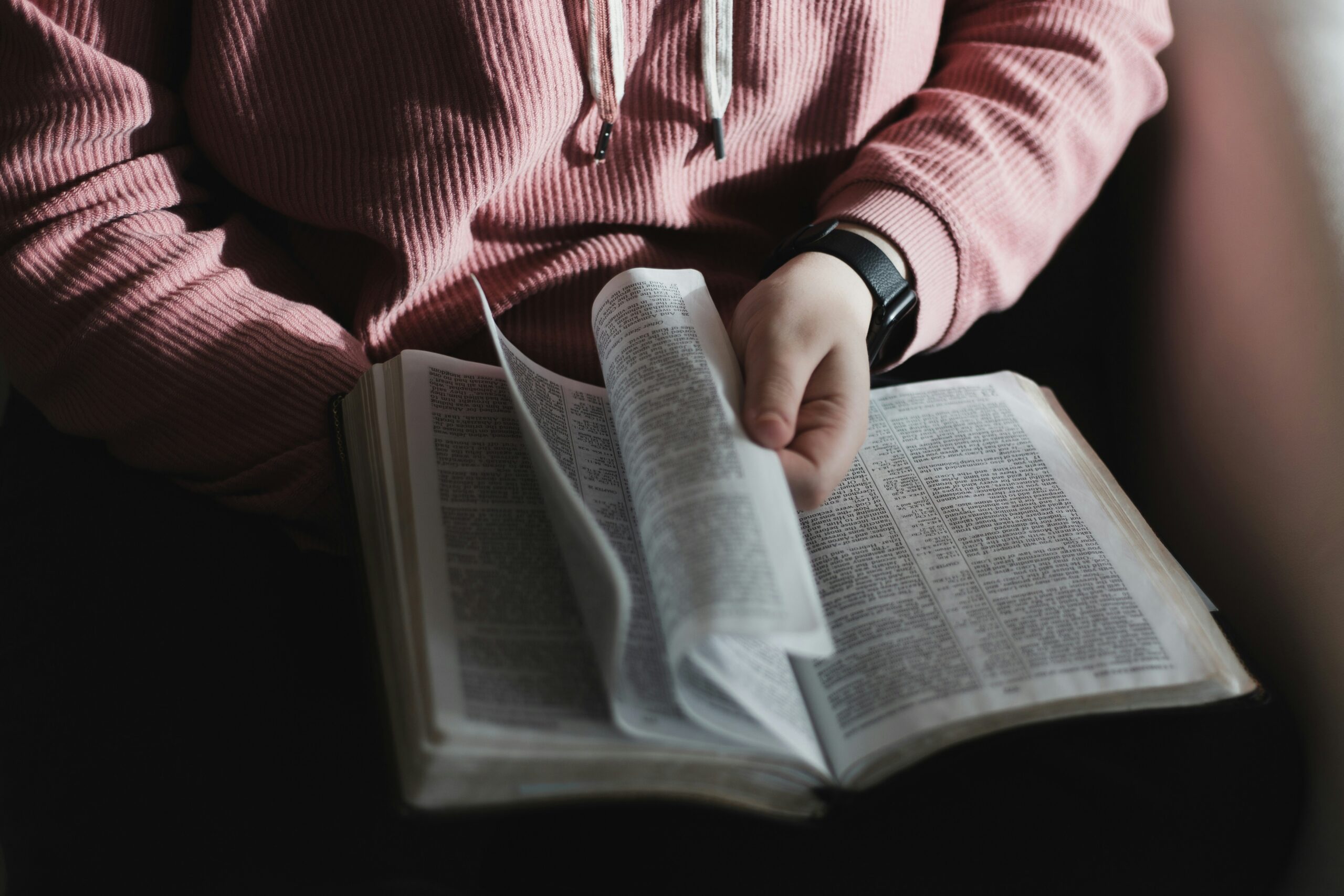 woman flipping through a bible